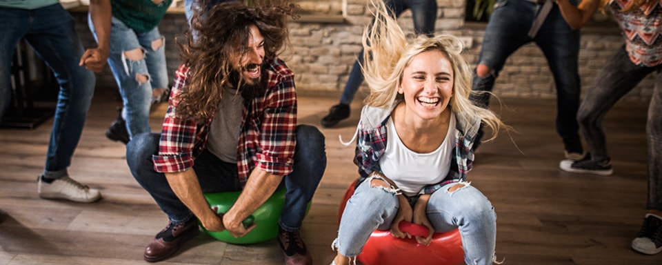 Blije collega's stuiteren met skippyballen door kantoor