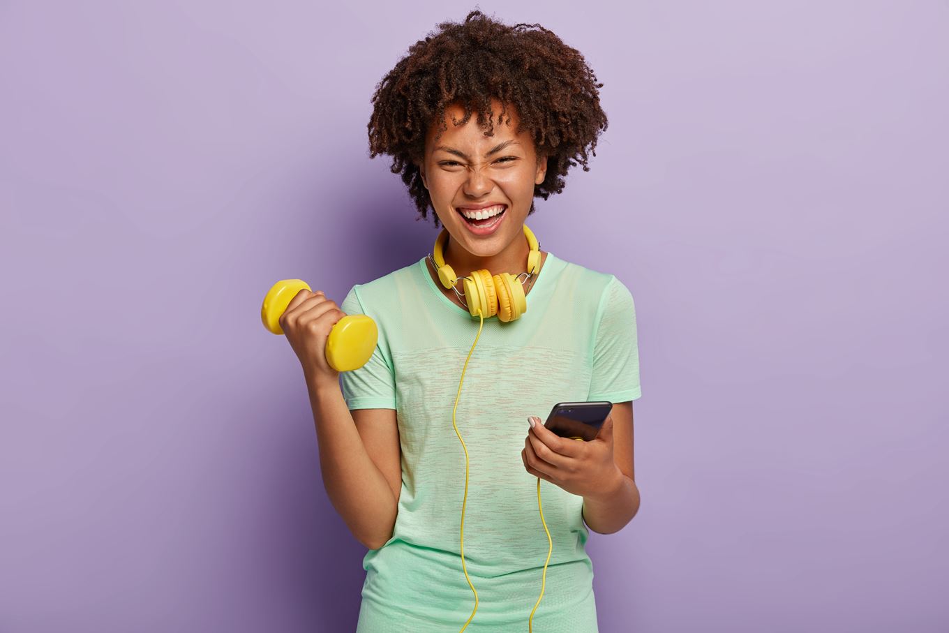 Lachende vrouw met een gewicht in haar hand