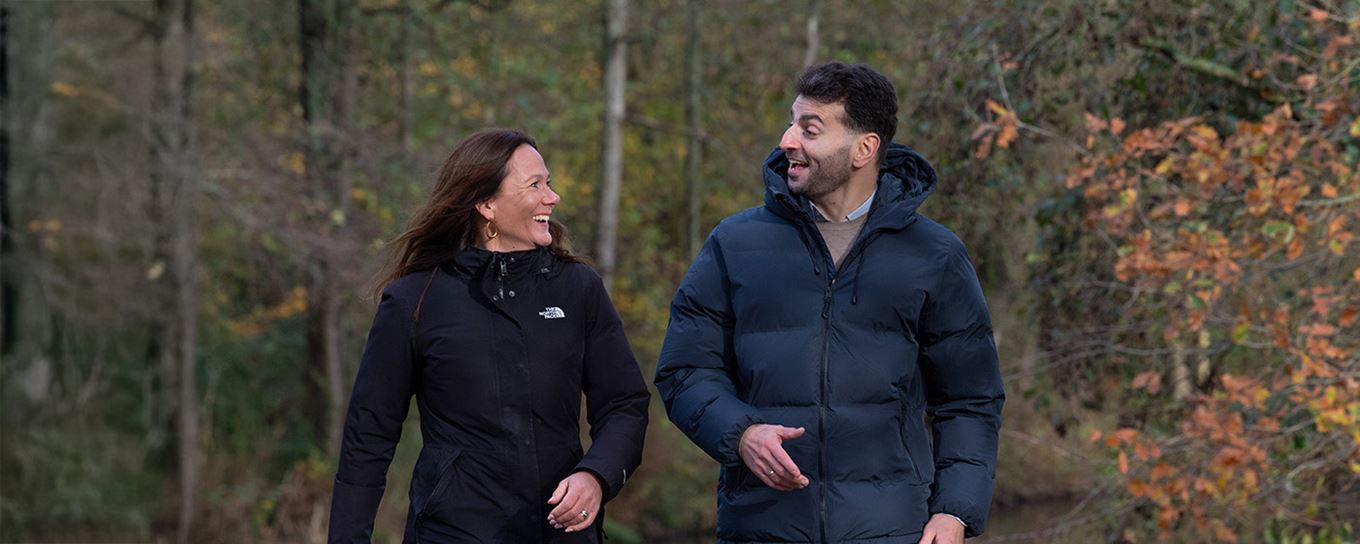 Man en vrouw vrolijk pratend aan de wandel