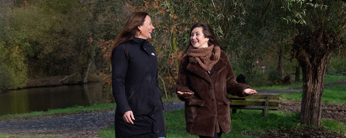 2 vrouwen vrolijk aan de wandel in een park