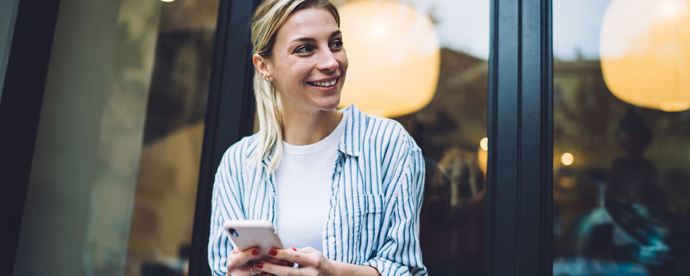 Afbeelding van een jonge vrouw met een mobiel in haar handen