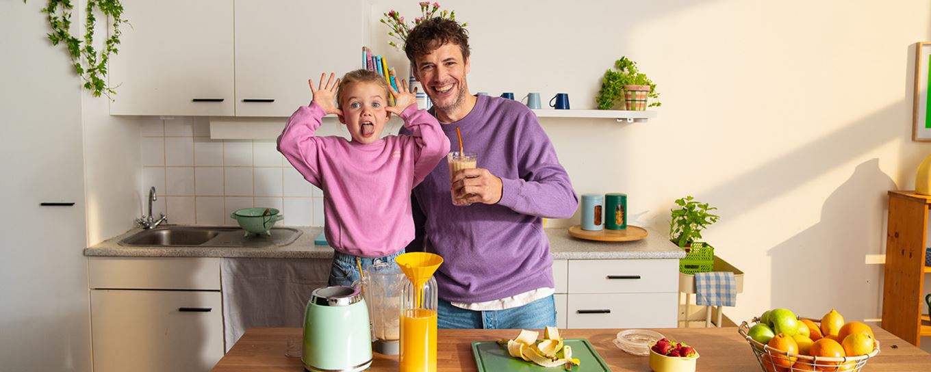 Afbeelding van een vader met zijn dochter waarvan de dochter de tong uitsteekt naar de camera