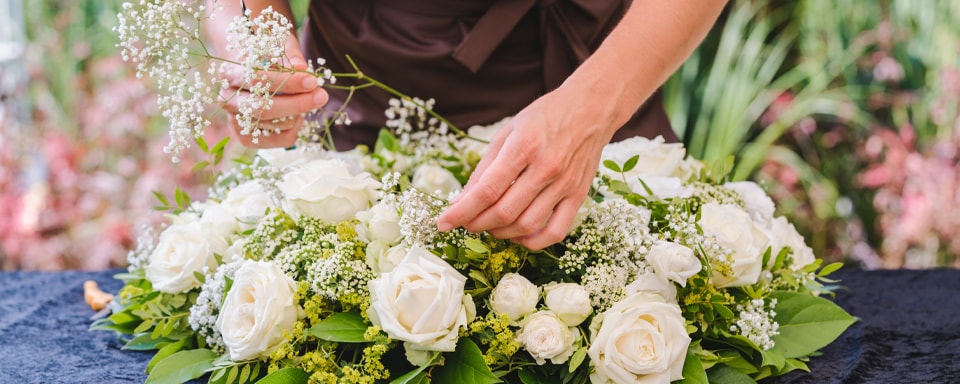 Iemand maakt wit bloemstuk