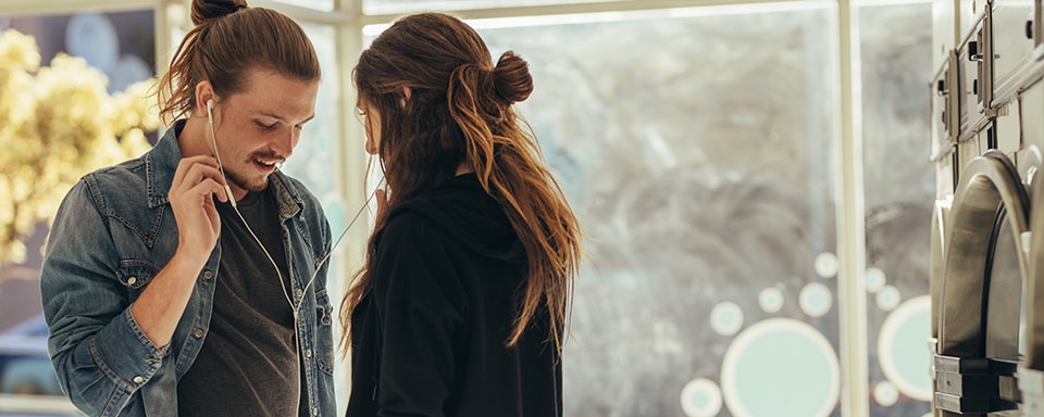 Jong koppel luistert muziek en delen oordopjes