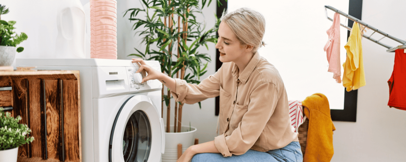 Jonge vrouw zet de wasmachine aan